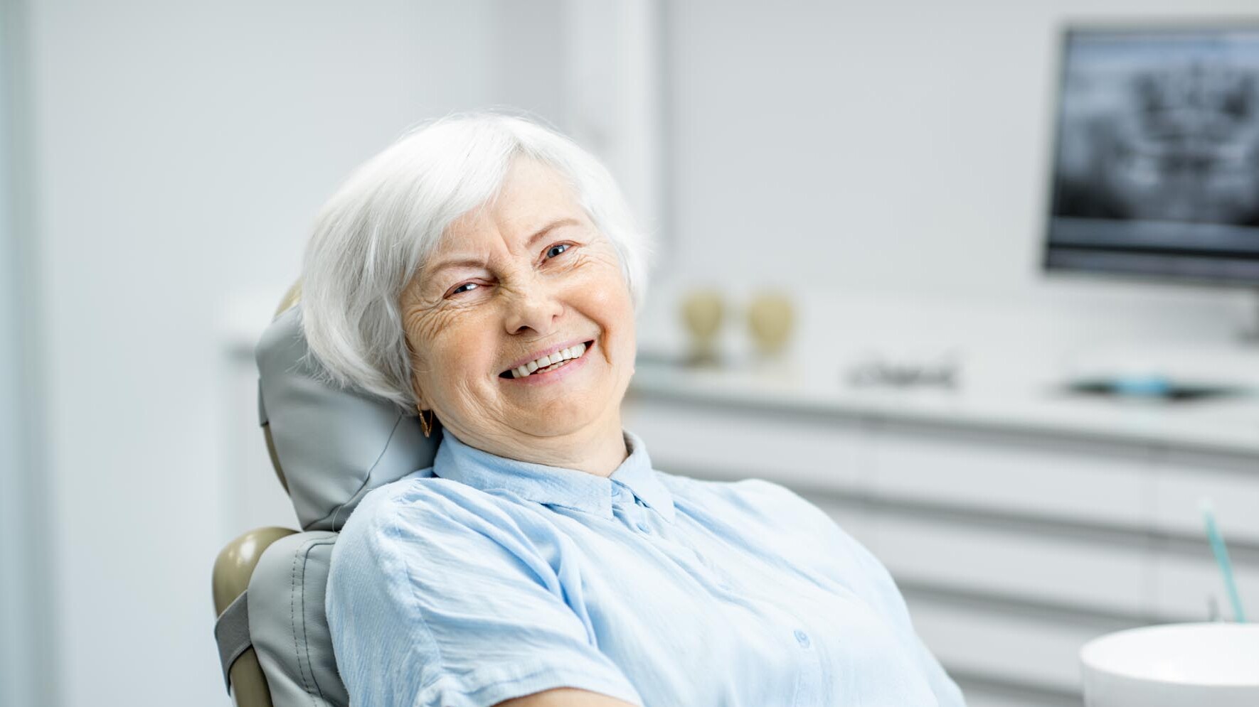 Bild einer lachenden Seniorin auf einem Behandlungsstuhl beim Zahnarzt. zahnarzt-muehlacker-ziegenhagel-iStock-1088392334.jpg